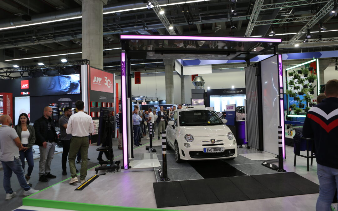 Quick-Check-Scanner mit Fahrzeug und Besuchern am TwoTronic-Messestand auf der Automechanika 2026