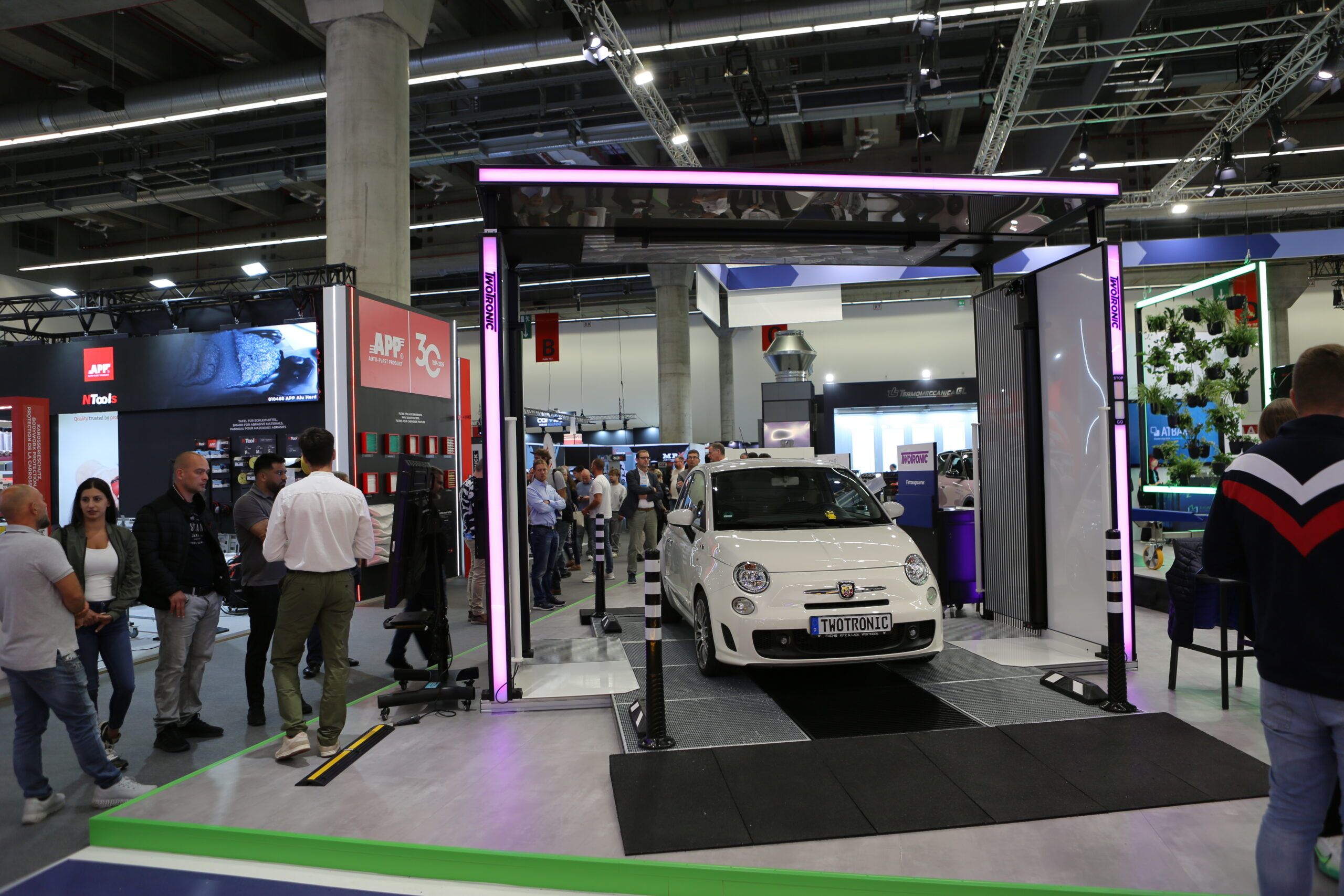 Quick-Check-Scanner mit Fahrzeug und Besuchern am TwoTronic-Messestand auf der Automechanika 2026